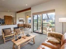 A living room with a sofa, coffee table, and dining area at Alpine Retreat - Ohakune Holiday Home in Ohakune