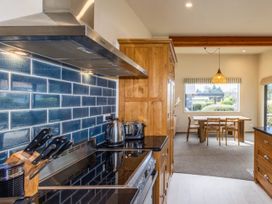 A kitchen with a stove and dining area at Alpine Retreat - Ohakune Holiday Home
