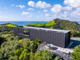 A house with a deck and hot tub near hills and ocean at Mangawhai Heads Holiday Home Mangawhai
