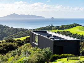 A house with windows overlooking the ocean at Mangawhai Heads Holiday Home Mangawhai