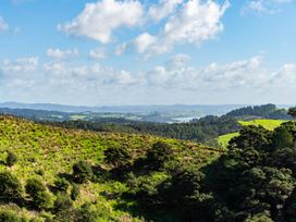 A landscape view of hills and fields at Mangawhai Heads Holiday Home in Mangawhai