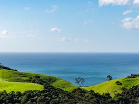 An ocean view with rolling hills and trees at Mangawhai Heads Holiday Home in Mangawhai