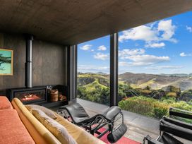 A living room with a fireplace and sofa at Mangawhai Heads Holiday Home in Mangawhai