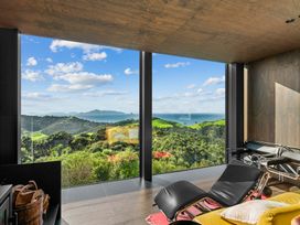 A living room with large windows and a landscape view at Mangawhai Heads Holiday Home Mangawhai