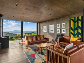 A living room with a view of mountains at Mangawhai Heads Holiday Home in Mangawhai