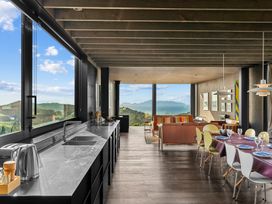 A kitchen with a dining area and cable TV at Mangawhai Heads Holiday Home in Mangawhai