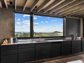 A kitchen with a sink and cabinets at Mangawhai Heads Holiday Home in Mangawhai