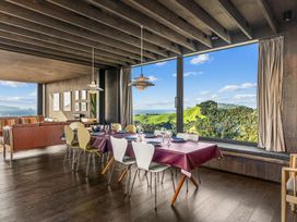 A dining area with a table and chairs at Mangawhai Heads Holiday Home in Mangawhai