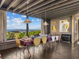 A dining room with a table and chairs at Mangawhai Heads Holiday Home in Mangawhai