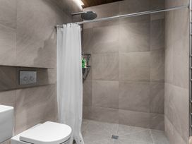A bathroom with a shower, toilet, and sink at Mangawhai Heads Holiday Home in Mangawhai