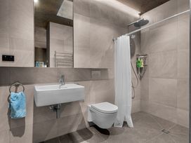 A bathroom with a shower, sink, and toilet at Mangawhai Heads Holiday Home, Mangawhai