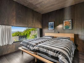 A bedroom with a double bed and window at Mangawhai Heads Holiday Home in Mangawhai