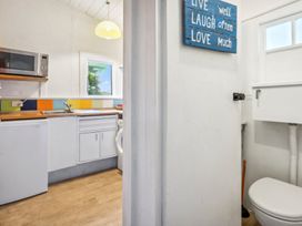 A kitchen with a microwave, sink, and fridge at Wellington Holiday home in Wellington