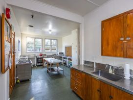 A kitchen with cabinets and cooking equipment at Taylor Lodge Adventure Base - Erua Holiday Home National Park