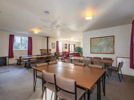 A common room with tables and chairs at Taylor Lodge Adventure Base - Erua Holiday Home, National Park