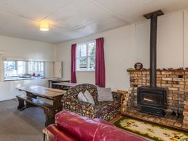 A living room with a sofa, dining table, and fireplace at Taylor Lodge Adventure Base - Erua Holiday Home National Park