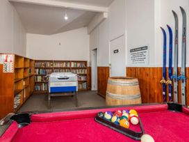 A recreation room with a pool table and bookshelf at Taylor Lodge Adventure Base - Erua Holiday Home National Park
