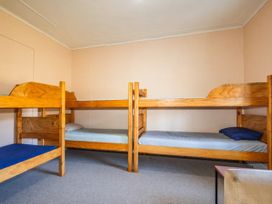A bedroom with bunk beds and a table at Taylor Lodge Adventure Base - Erua Holiday Home National Park