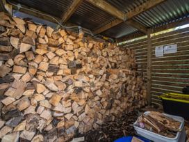 A wood storage area with stacked firewood at Taylor Lodge Adventure Base - Erua Holiday Home National Park