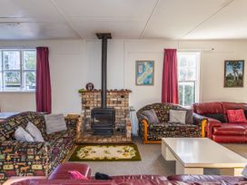 A living room with a fireplace and seating at Taylor Lodge Adventure Base - Erua Holiday Home in National Park