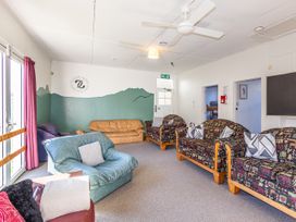 A common room with couches and a ceiling fan at Taylor Lodge Adventure Base - Erua Holiday Home National Park