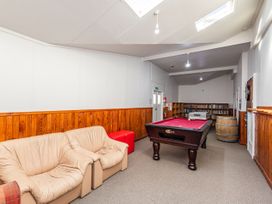 A recreation room with a pool table and bookshelf at Taylor Lodge Adventure Base - Erua Holiday Home in National Park
