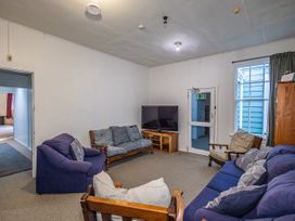 A living room with sofas and a television at Taylor Lodge Adventure Base -  Erua Holiday Home National Park