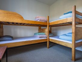 A bedroom with bunk beds and bedding at Taylor Lodge Adventure Base - Erua Holiday Home National Park