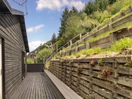 An outdoor deck with a landscaped garden at Alpine Luxe - Queenstown Holiday Home in Queenstown