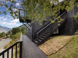 A wooden staircase leading to a black house with a deck at Alpine Luxe - Queenstown Holiday Home Queenstown
