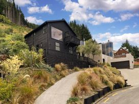 A house with a balcony and driveway at Alpine Luxe - Queenstown Holiday Home, Queenstown