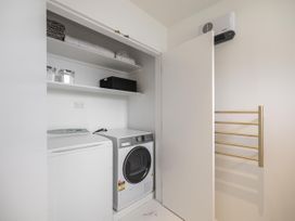 A laundry room with a washing machine and dryer at Alpine Luxe - Queenstown Holiday Home, Queenstown