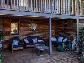An outdoor seating area with sofas and a table at Coastal Serenity - Te Tii Escape