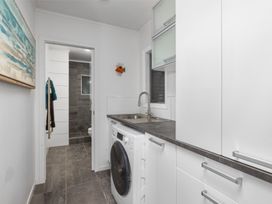 A laundry room with a washing machine and sink at Coastal Serenity - Te Tii Escape