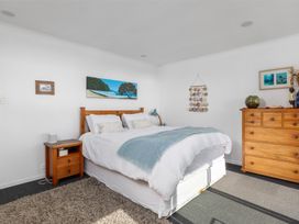A bedroom with a bed and nightstand at Coastal Serenity - Te Tii Escape