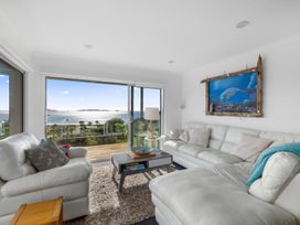 A living room with a sofa and a table at Coastal Serenity - Te Tii Escape