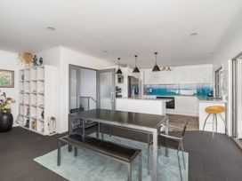 A dining room with a table and chairs at Coastal Serenity - Te Tii Escape