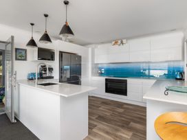 A kitchen with modern appliances and fixtures at Coastal Serenity - Te Tii Escape