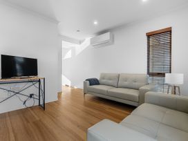 A living room with a sofa and a TV stand at Hamilton in Hamilton