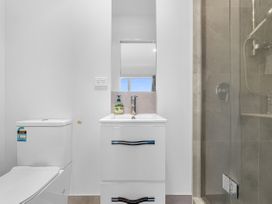 A bathroom with a toilet, sink, mirror, and shower at Hamilton