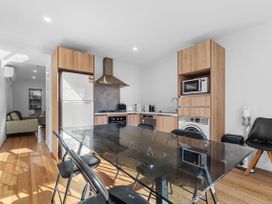 A kitchen with appliances and a glass dining table at Hamilton in Hamilton