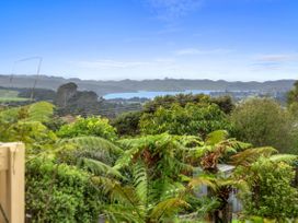 A view of hills and ocean with greenery at Raglan Holiday Home in Raglan
