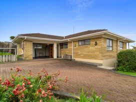 A house with a driveway and garden at Raglan Holiday Home in Raglan