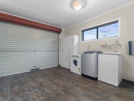 A laundry room with washing machine and dryer at Raglan Holiday Home in Raglan