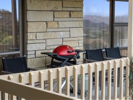 An outdoor area with a grill and chairs at Raglan Holiday Home in Raglan