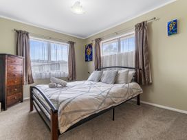 A bedroom with a bed and dresser at Raglan Holiday Home Raglan