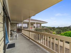 A balcony with chairs and a view at Raglan Holiday Home in Raglan