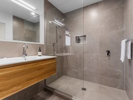A bathroom with a shower and sink at Raglan Holiday Home in Raglan