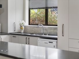 A kitchen with a sink and dishwasher at Raglan Holiday Home in Raglan