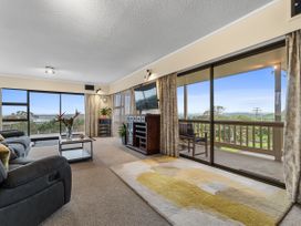 A living room with sofa and coffee table at Raglan Holiday Home in Raglan